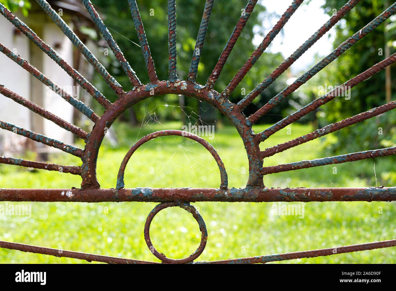 a rusty fence – vintage ironwork in a lush green setting - Stock Image