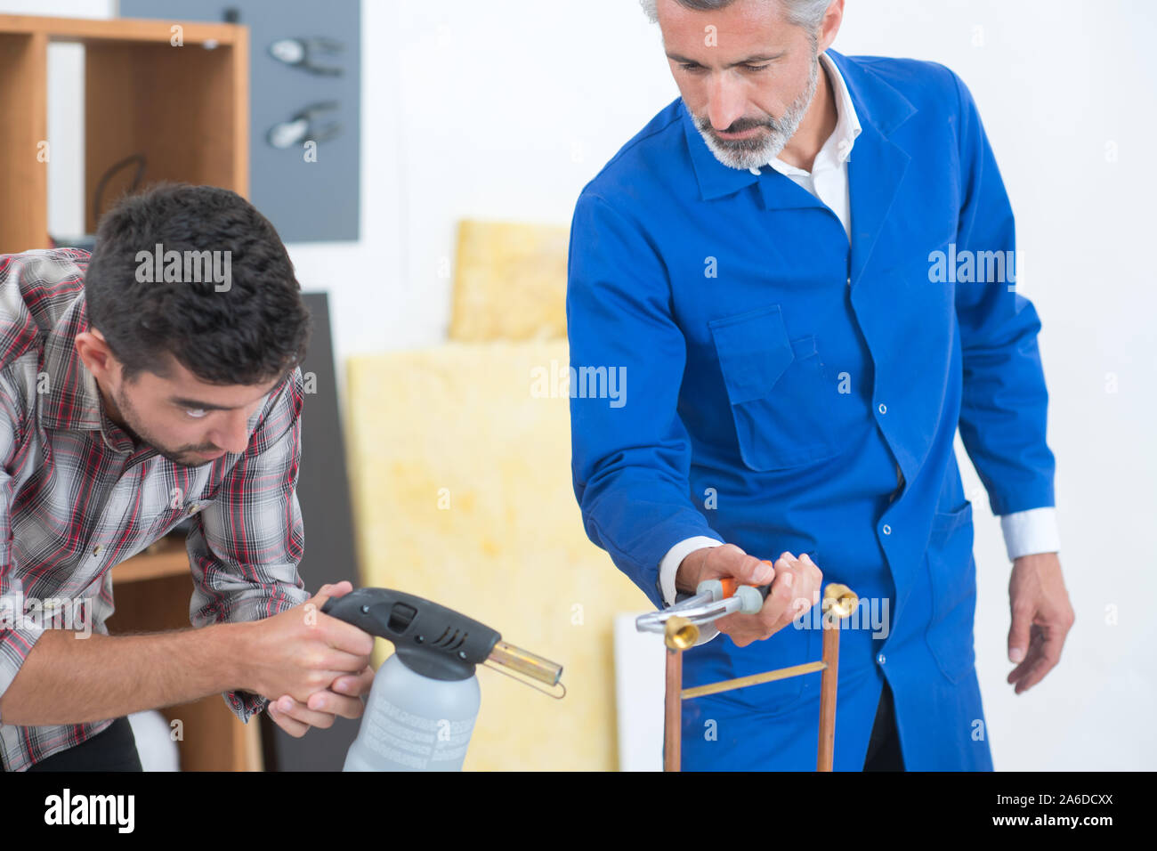 two industrial worker using gas torch for soldering copper pipes Stock