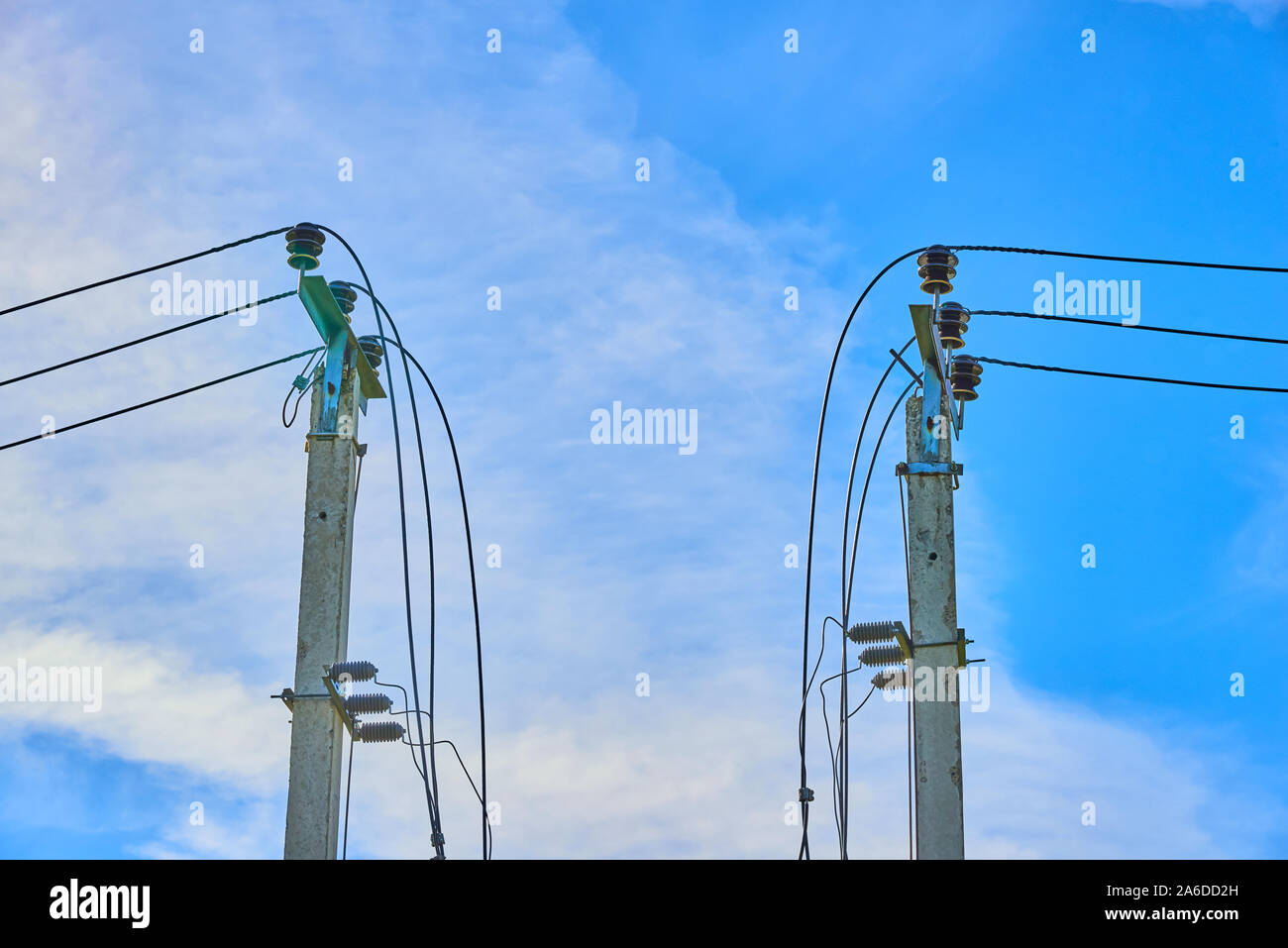 Electrical high voltage fuses on the grey concrete pillars on the blue clear sky on the background Stock Photo