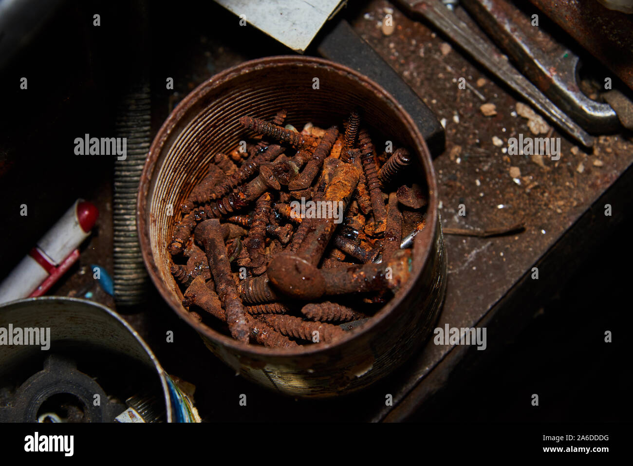 Rusty bolts and screws in metal box on the workbench. Stock Photo