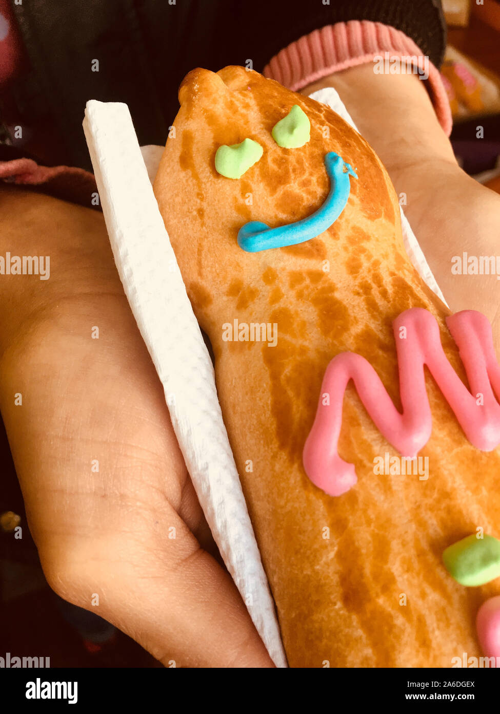 GUAGUA DE PAN - Bread boy in Spanish language - Close-up on the hands of a woman holding a bread on a napkin. Stock Photo