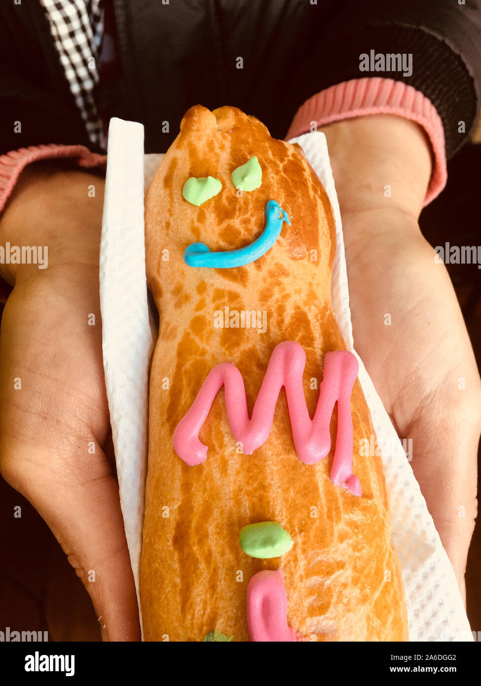 GUAGUA DE PAN - Bread boy in Spanish language - Close-up on the hands of a woman holding a bread on a napkin. Stock Photo