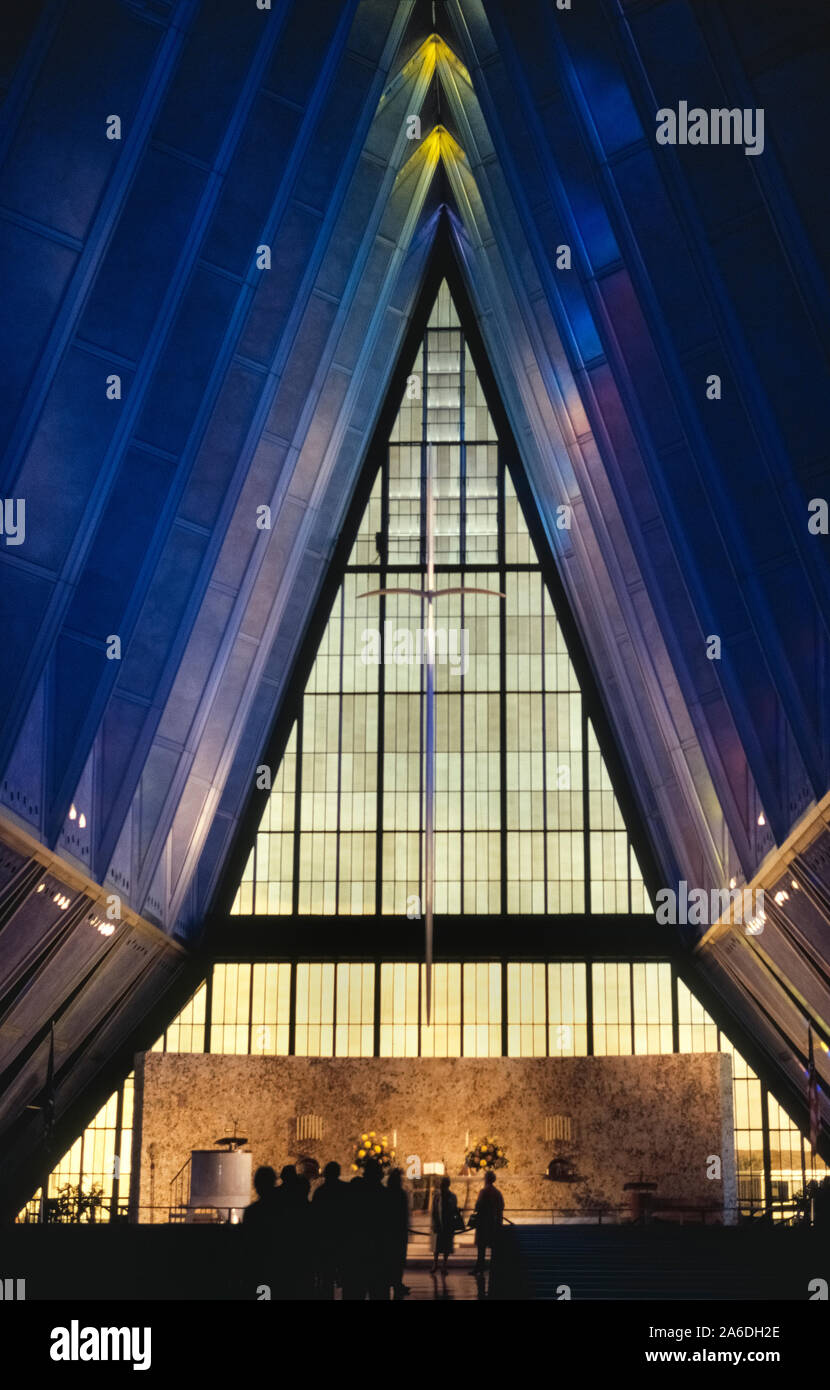 This imposing interior photograph shows a classic example of American modern architecture, the stunning U.S. Air Force Academy Chapel, which is the most visited man-made tourist attraction in Colorado, USA. The structure's exterior is easily identified by its 17 steel, aluminum and glass spires that soar 150 feet (46 meters) into the sky at Colorado Springs. The chapel opened in 1962 to meet the spiritual needs of cadets during their undergraduate education at the academy to become officers in the United States Air Force. The chapel closed to the public in 2019 for a 3- to 4-year renovation. Stock Photo