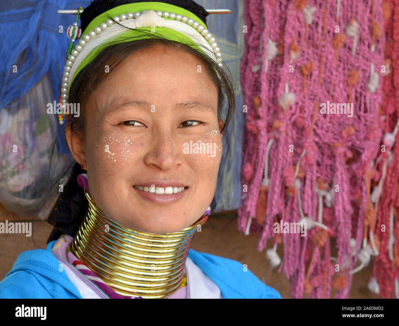 Young Myanmarese Kayan Lahwi longneck woman (“giraffe woman”) with brass neck rings smiles for the camera. Stock Photo