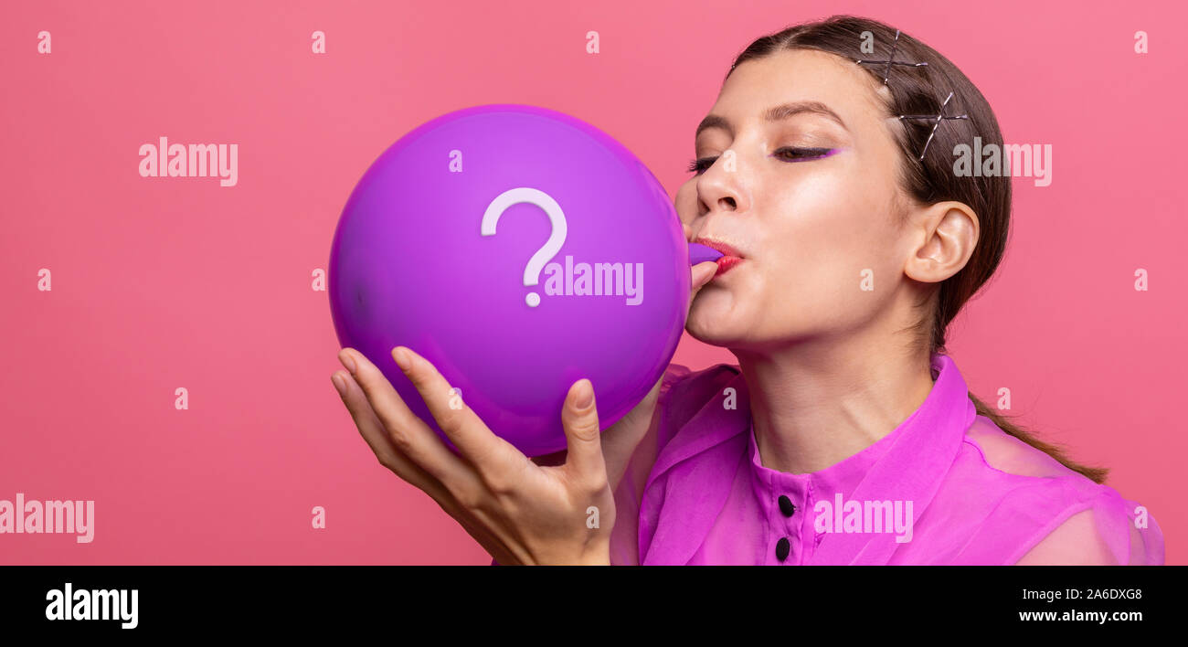 girl inflates the balloon with a question Stock Photo