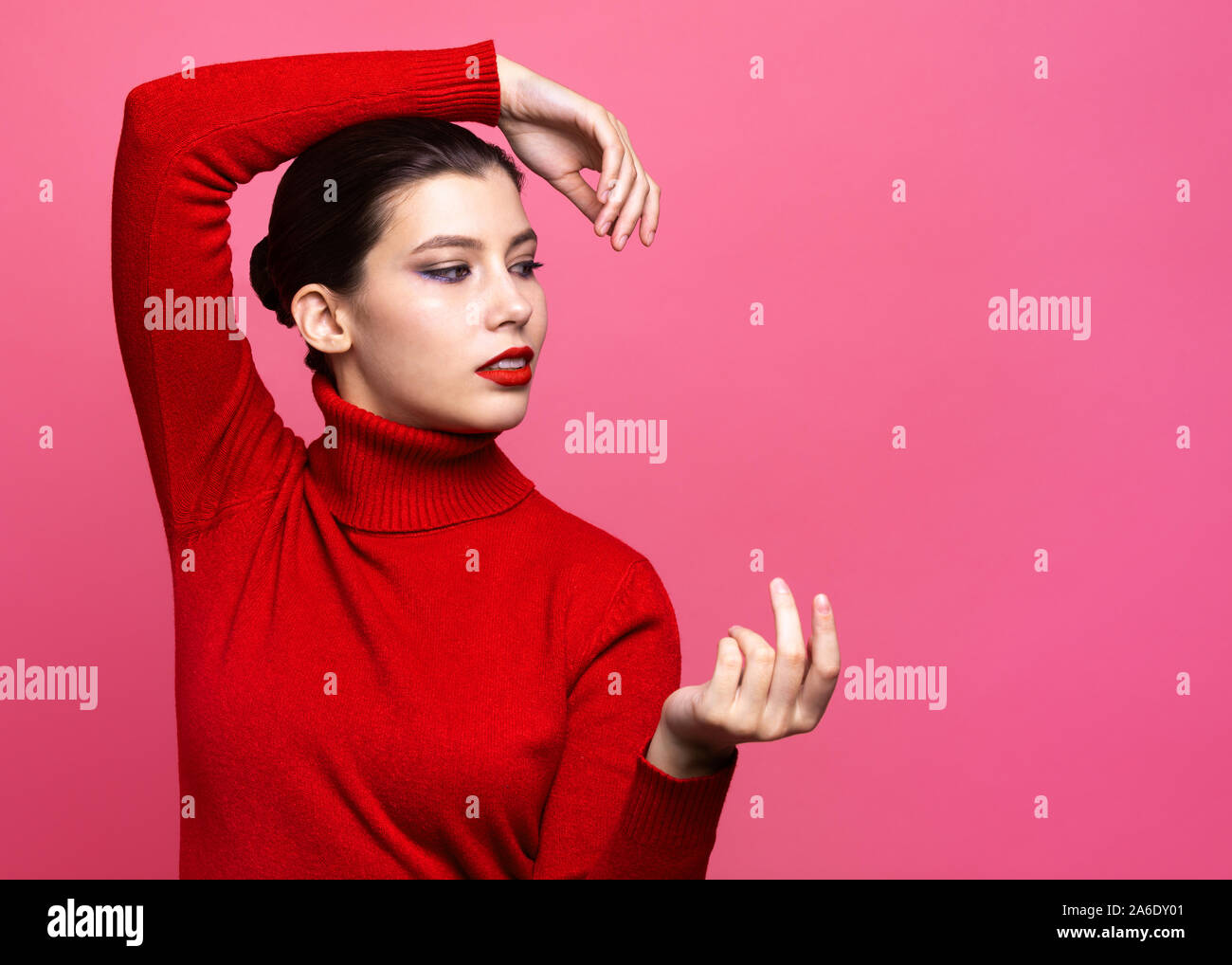 girl in red sweater posing on pink background Stock Photo