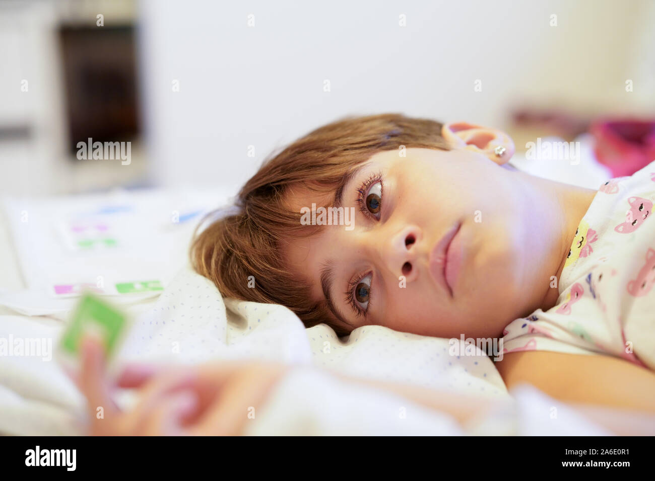 Little girl, eight years old, lying on her bed Stock Photo