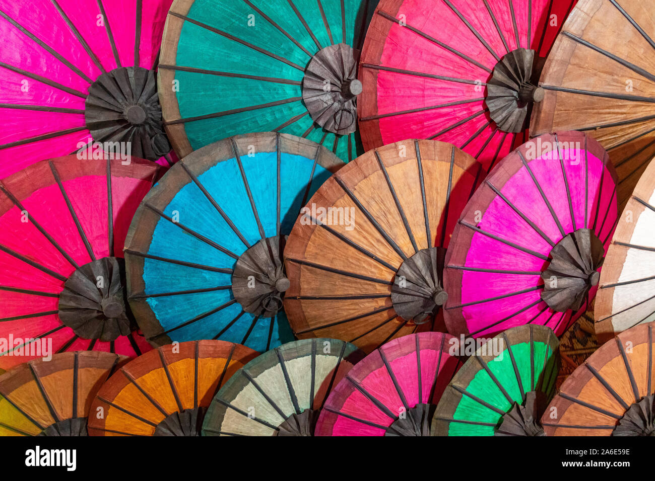 Colorful handmade Asian umbrellas on display at night market in Luang
