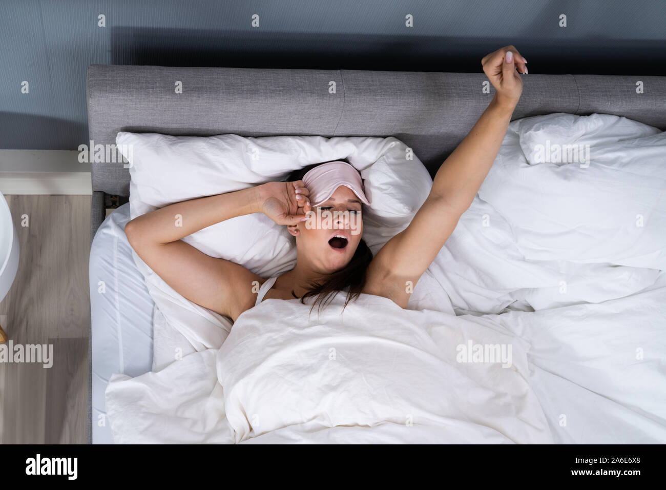 Woman Yawning While Waking Up In Bed Stock Photo - Alamy