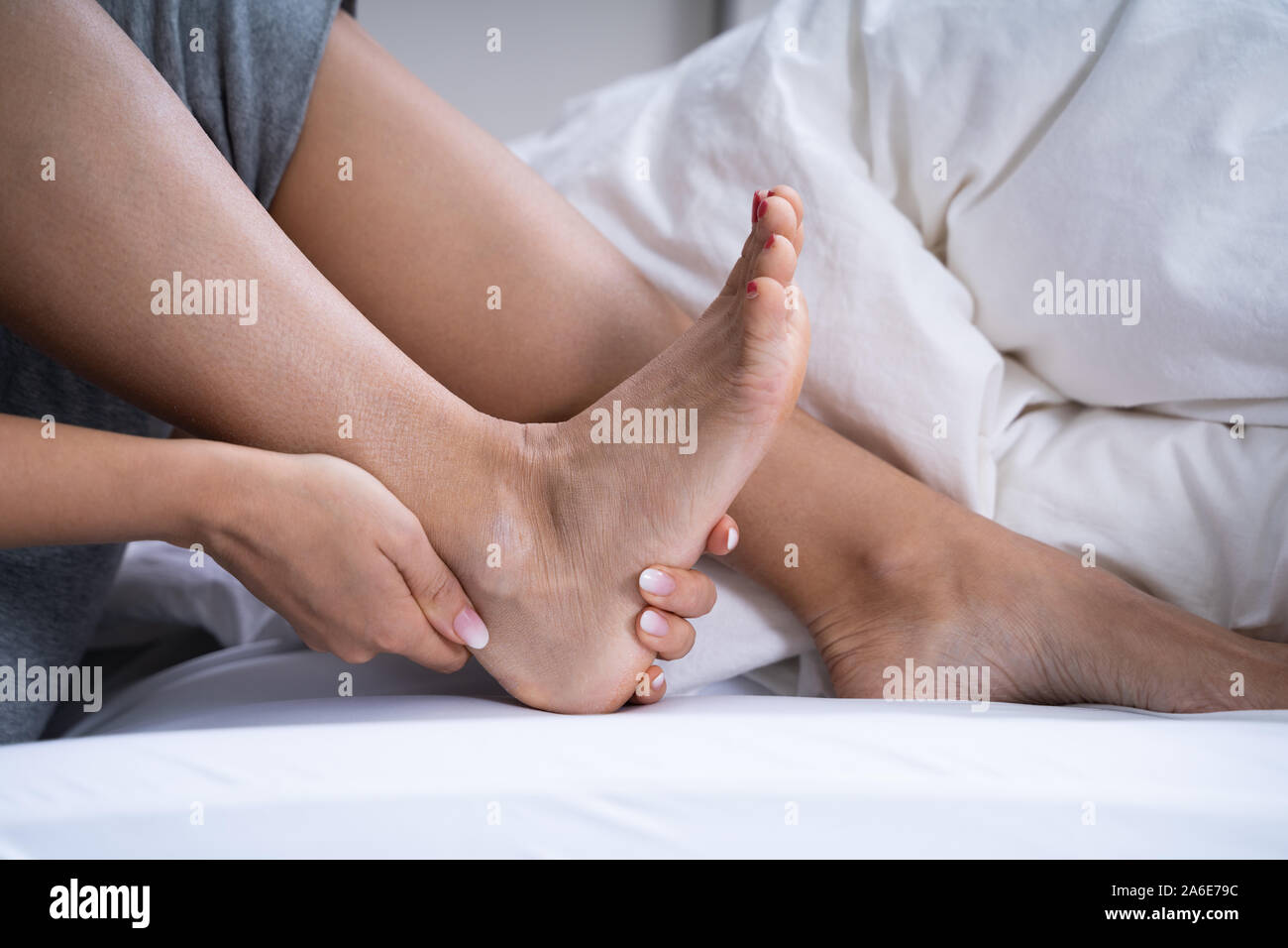 Woman Feeling Achilles Heel Pain In Bed Stock Photo