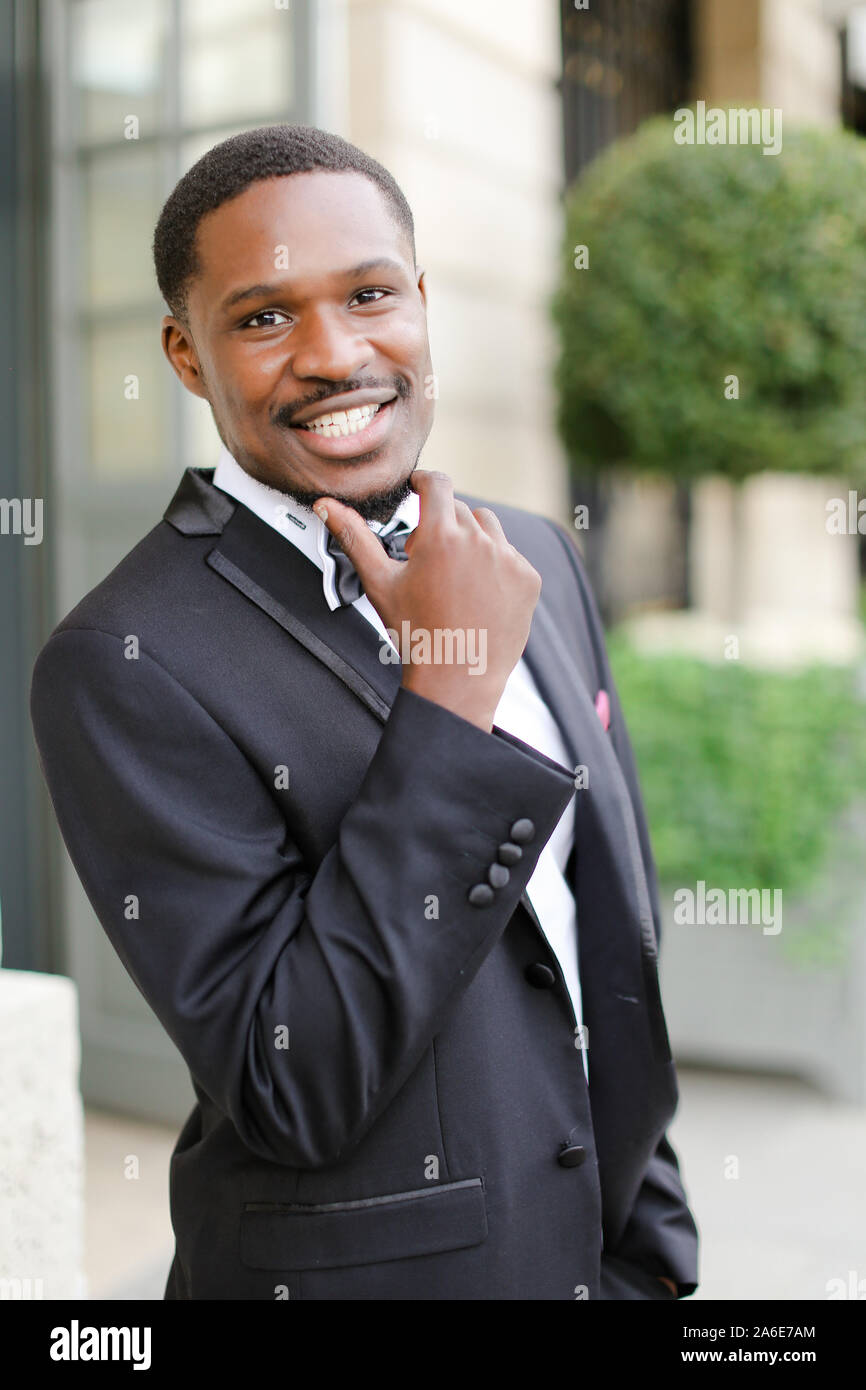 Afro american happy good looking man wearing suit and smiling outdoors ...