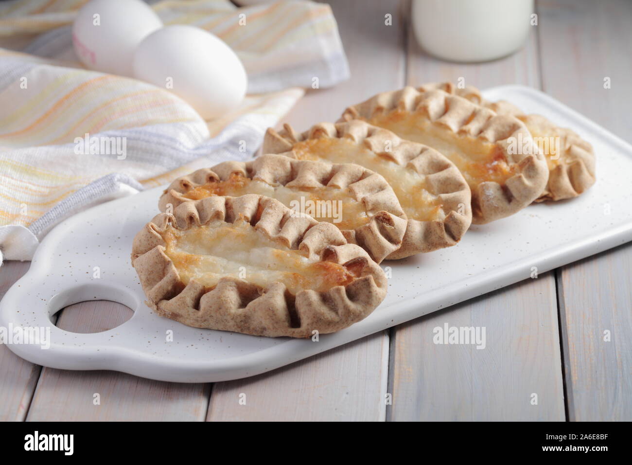 Karjalanpiirakat, Karelian pasties on a cutting board against eggs. Today it is a national dish in Finland Stock Photo