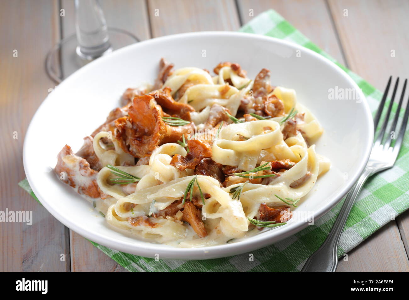 Fettuccine Alfredo with Chanterelle mushrooms and rosemary on a rustic