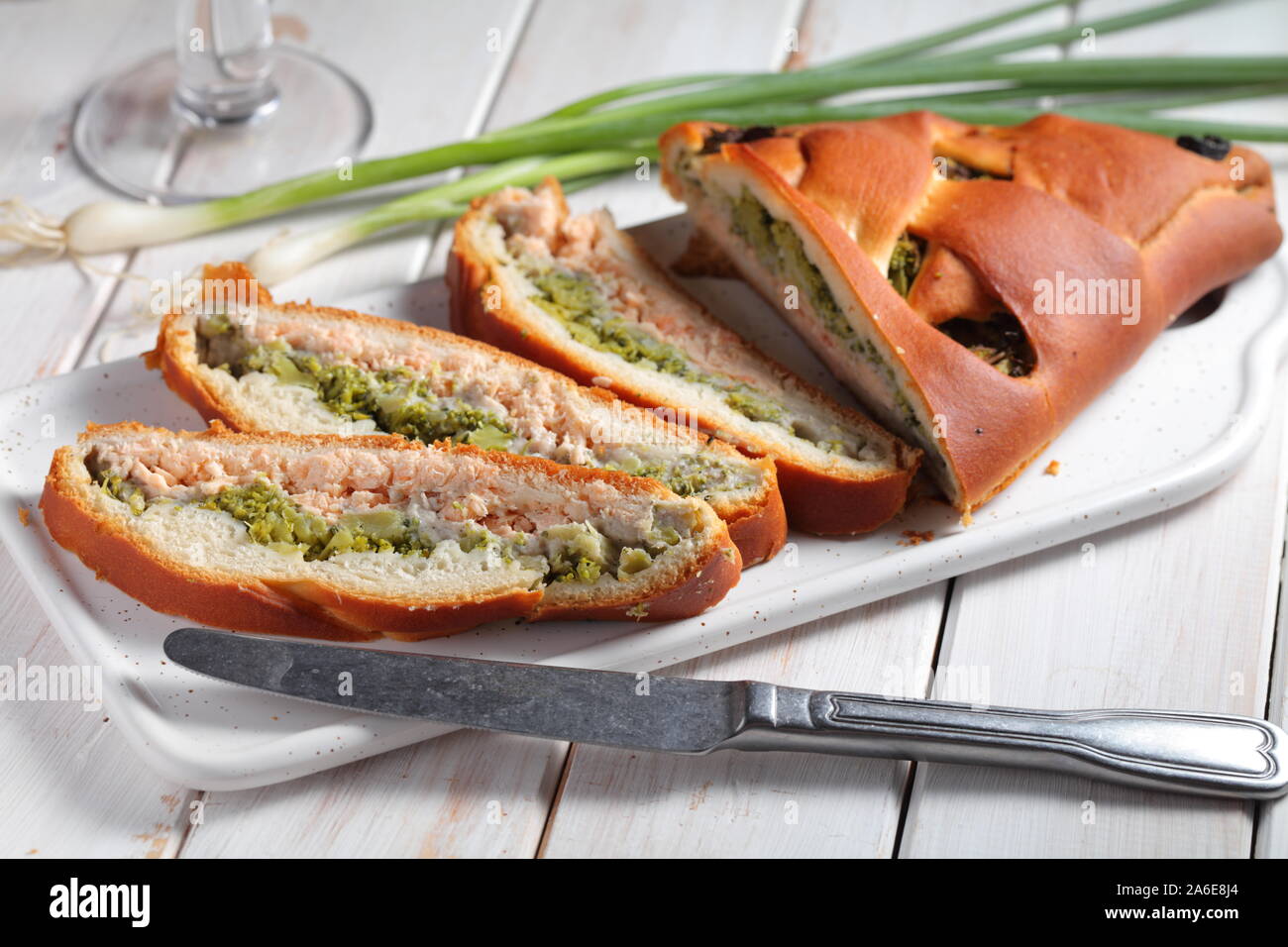 Sliced salmon and broccoli pie on a rustic table Stock Photo