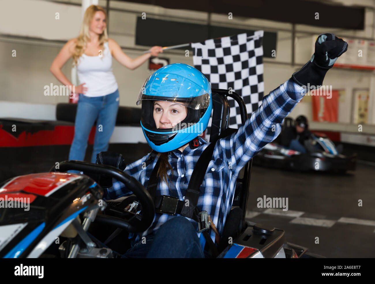 Lucky adult female go-cart racer crossing finish line Stock Photo - Alamy