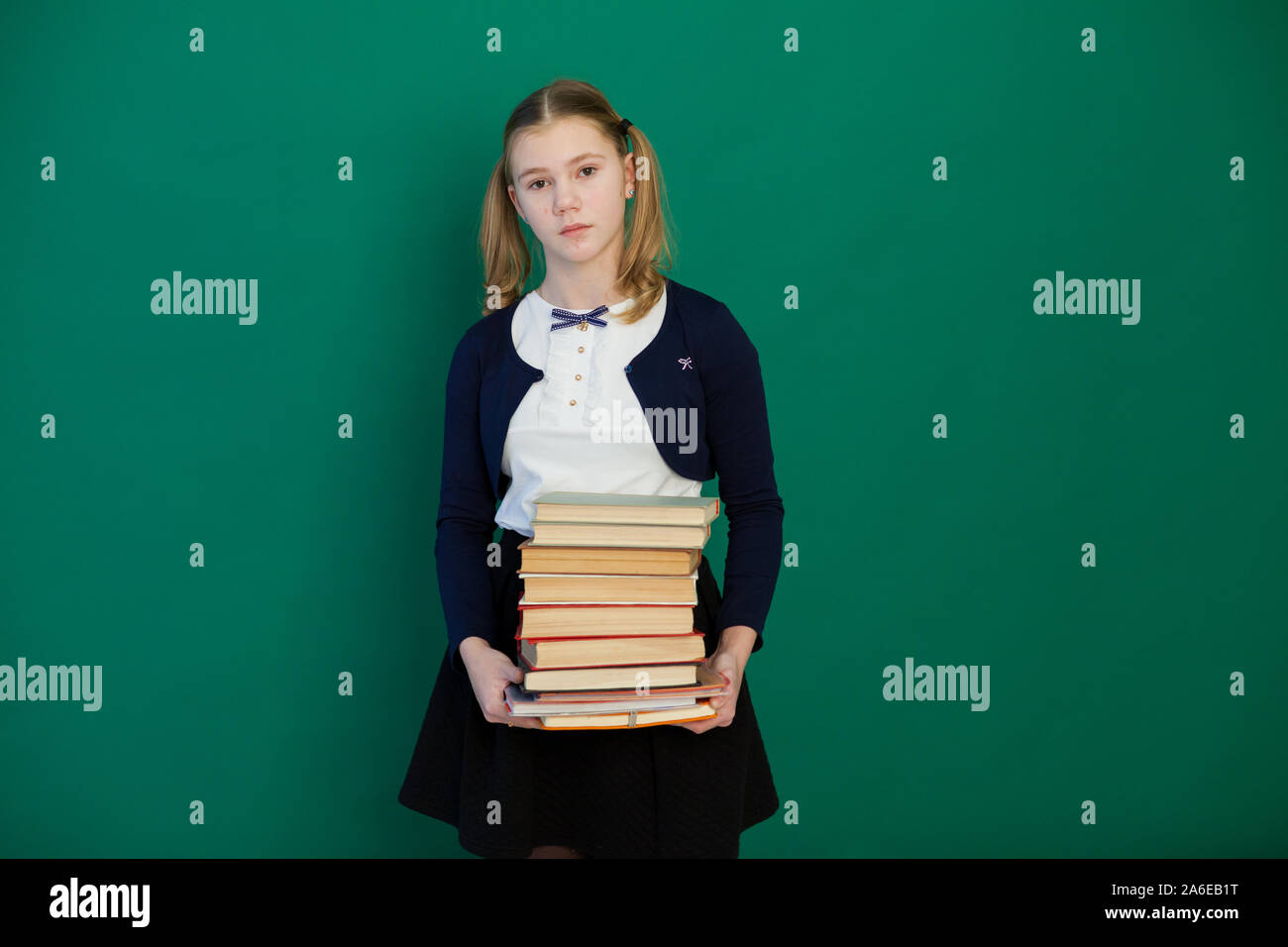 schoolgirl girl stands with books in the classroom Stock Photo - Alamy