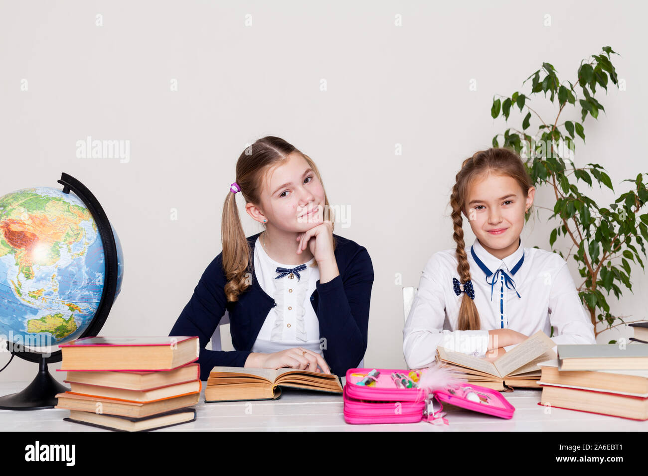two girls at the desk with books at school Stock Photo - Alamy