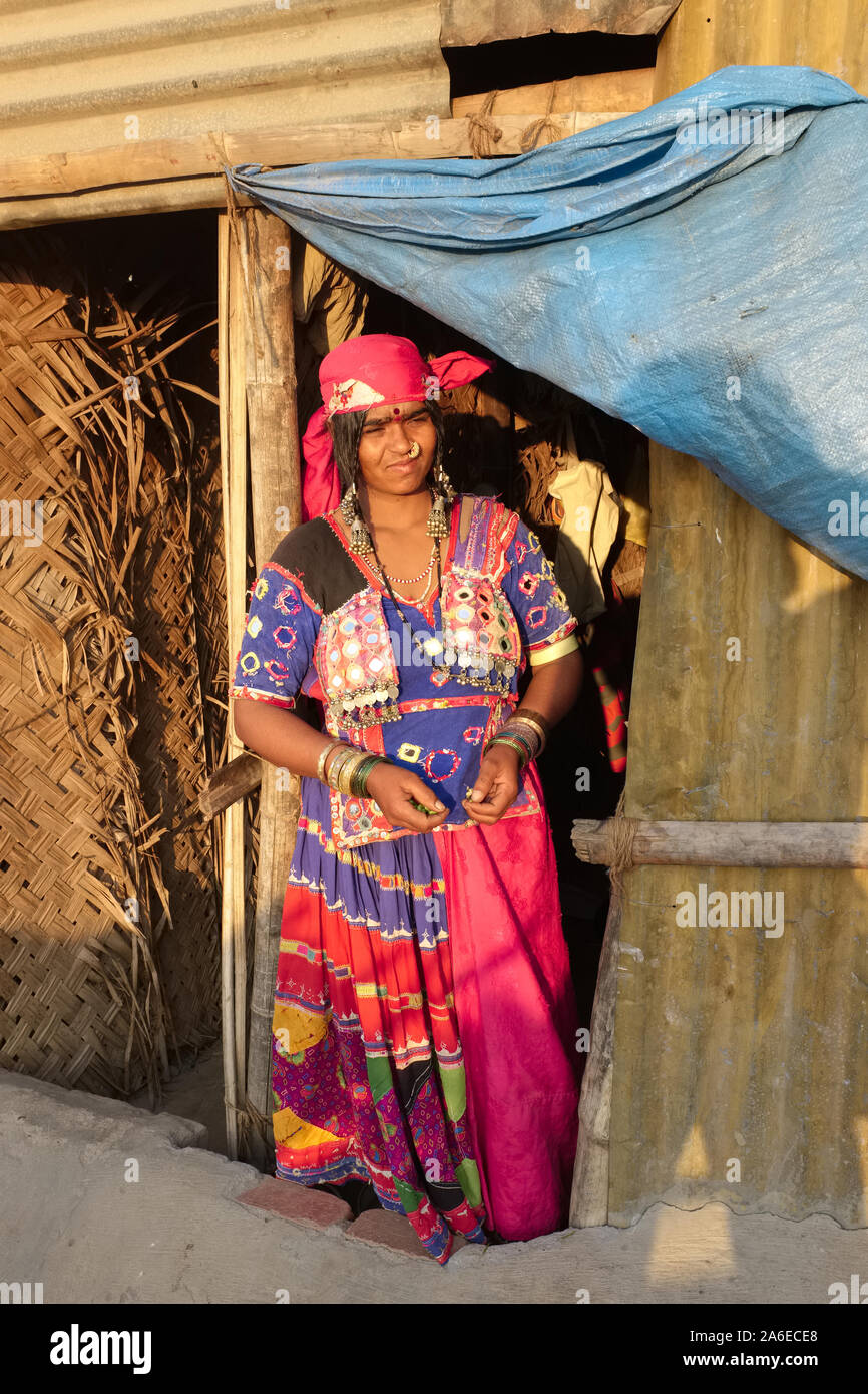 A woman of the gypsy-like Lambari tribe in in her make-shift metal-and thatch hut next to the construction site her husband works at; Mangalore, India Stock Photo