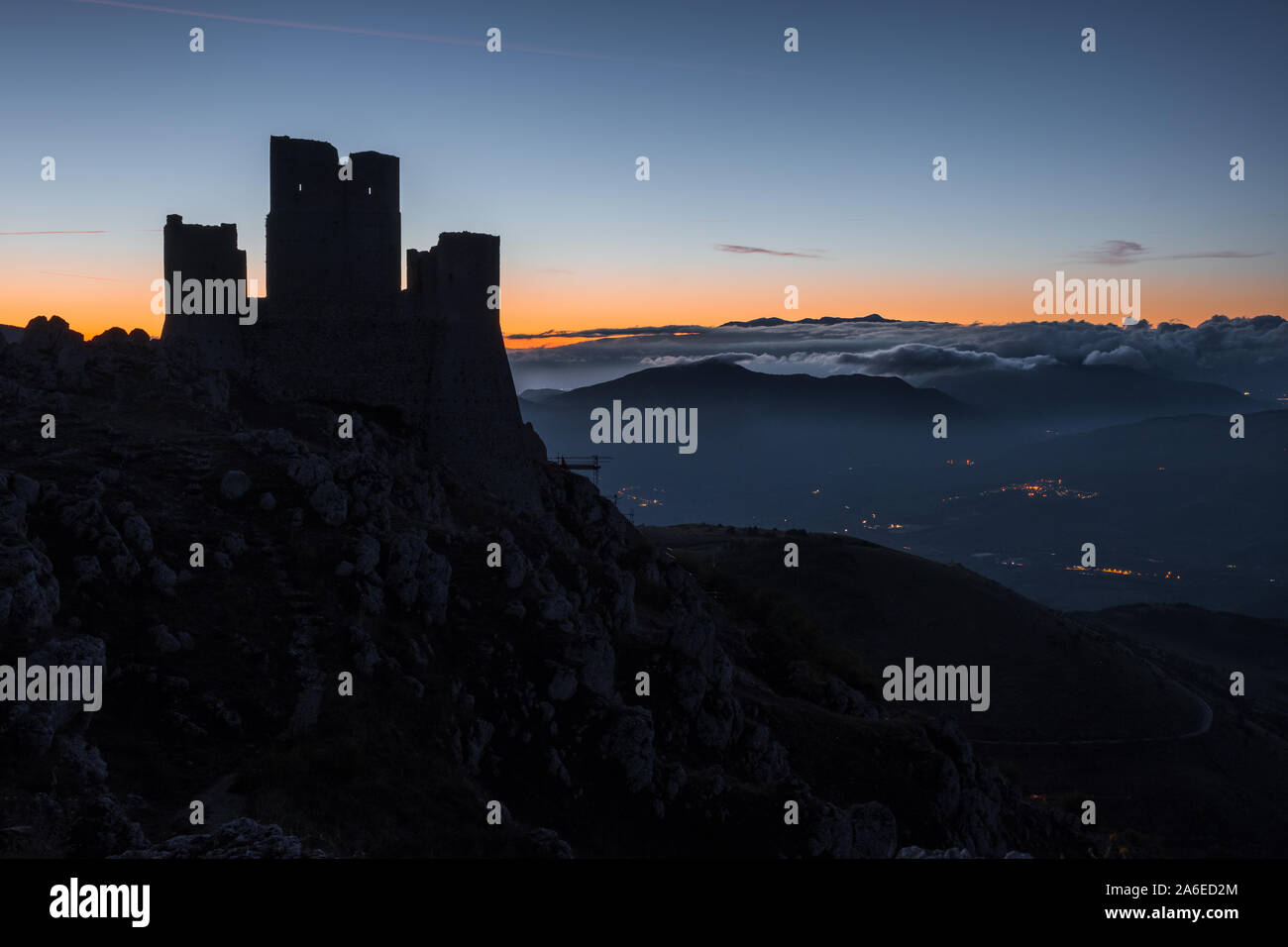 Silhouette of Ruins of medieval castle of Rocca Calascio at sunrise, with foggy mountain landscape in background , Abruzzo, Italy Stock Photo