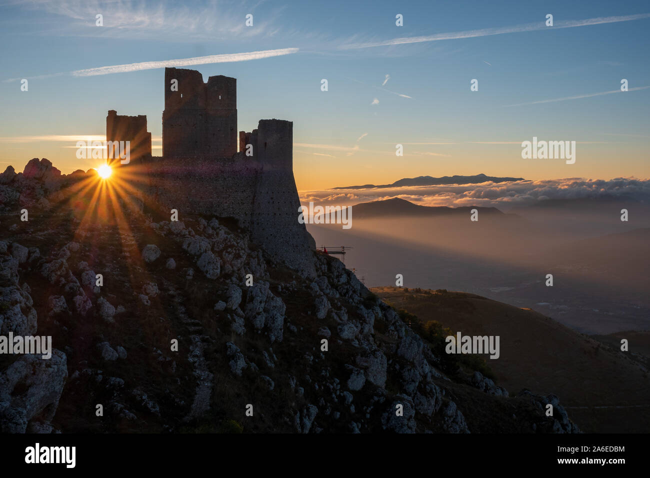 Ruins of medieval castle of Rocca Calascio at sunny morning, with foggy landscape in background and sunstar, Abruzzo, Italy Stock Photo