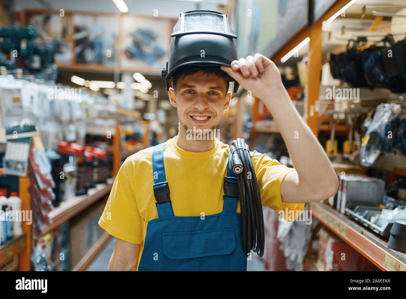 Builder choosing welding helmet in hardware store Stock Photo