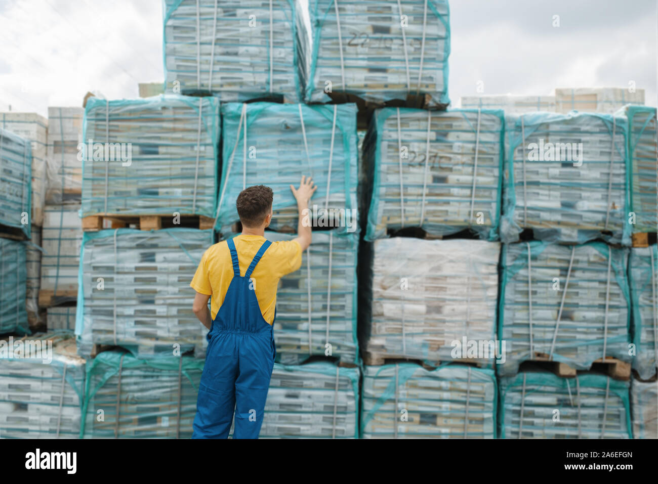 Male builder check palettes with wooden boards Stock Photo - Alamy
