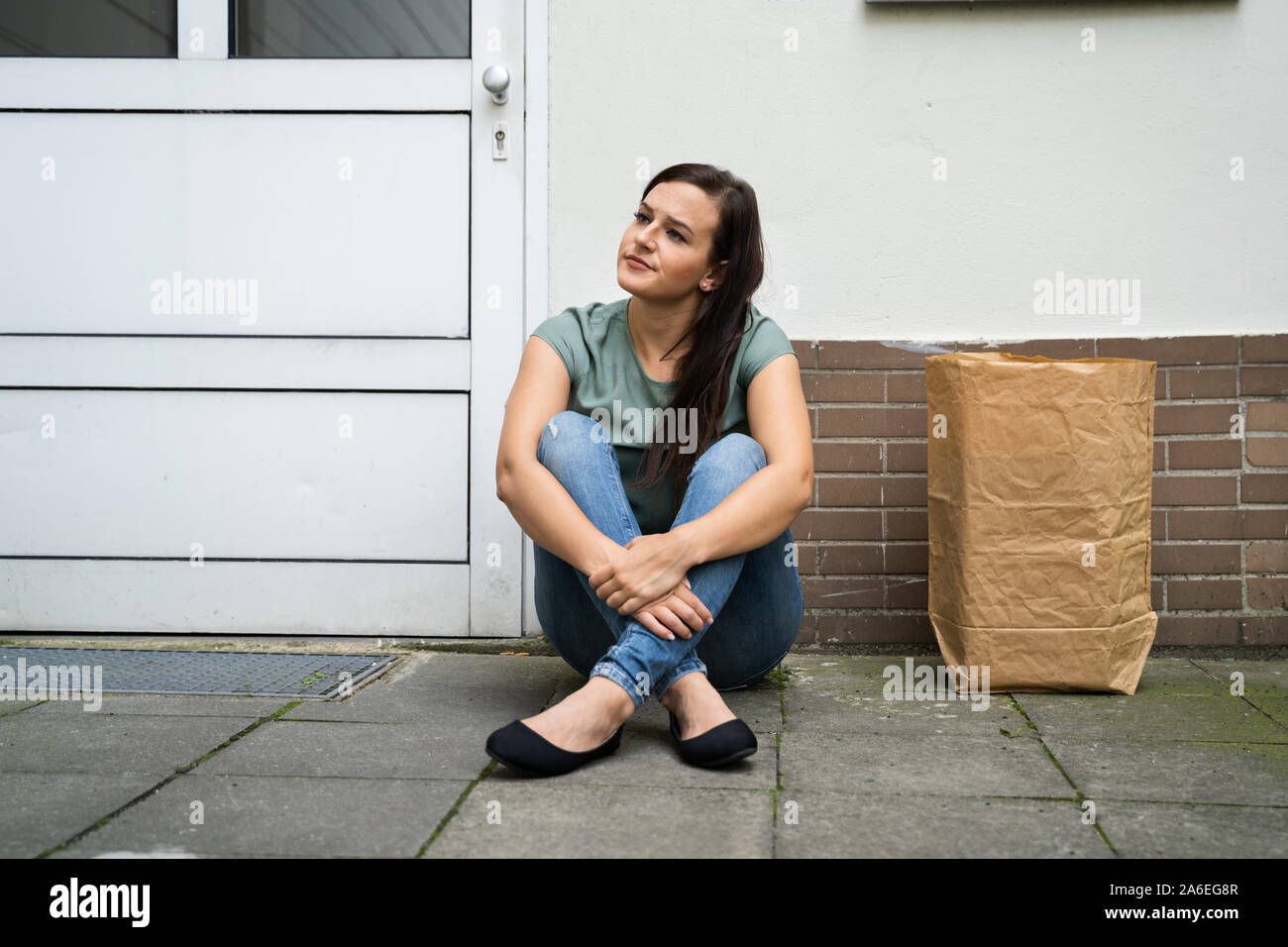 Young Woman Waiting In Front Of Closed Door Stock Photo