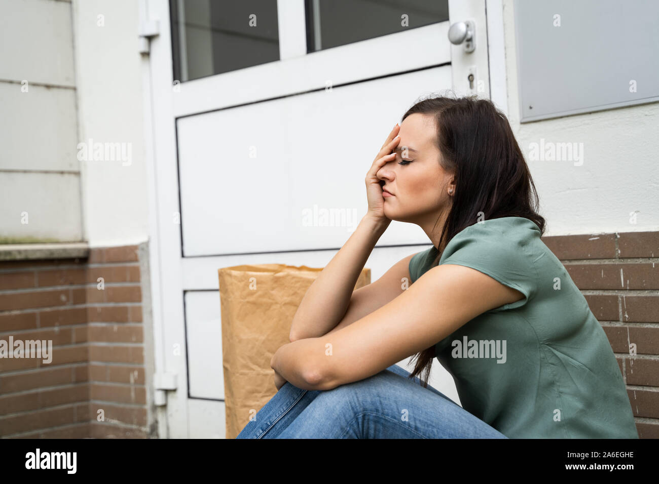 Young Woman Waiting In Front Of Closed Door Stock Photo