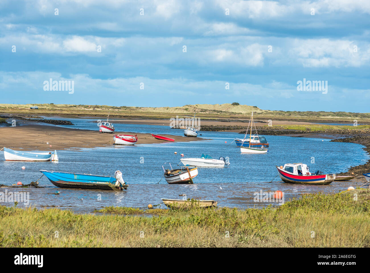 Colourful boats on river Burn estuary at high tide, seen from Norfolk Coast path National Trail near Burnham Overy Staithe, East Anglia, England, UK. Stock Photo