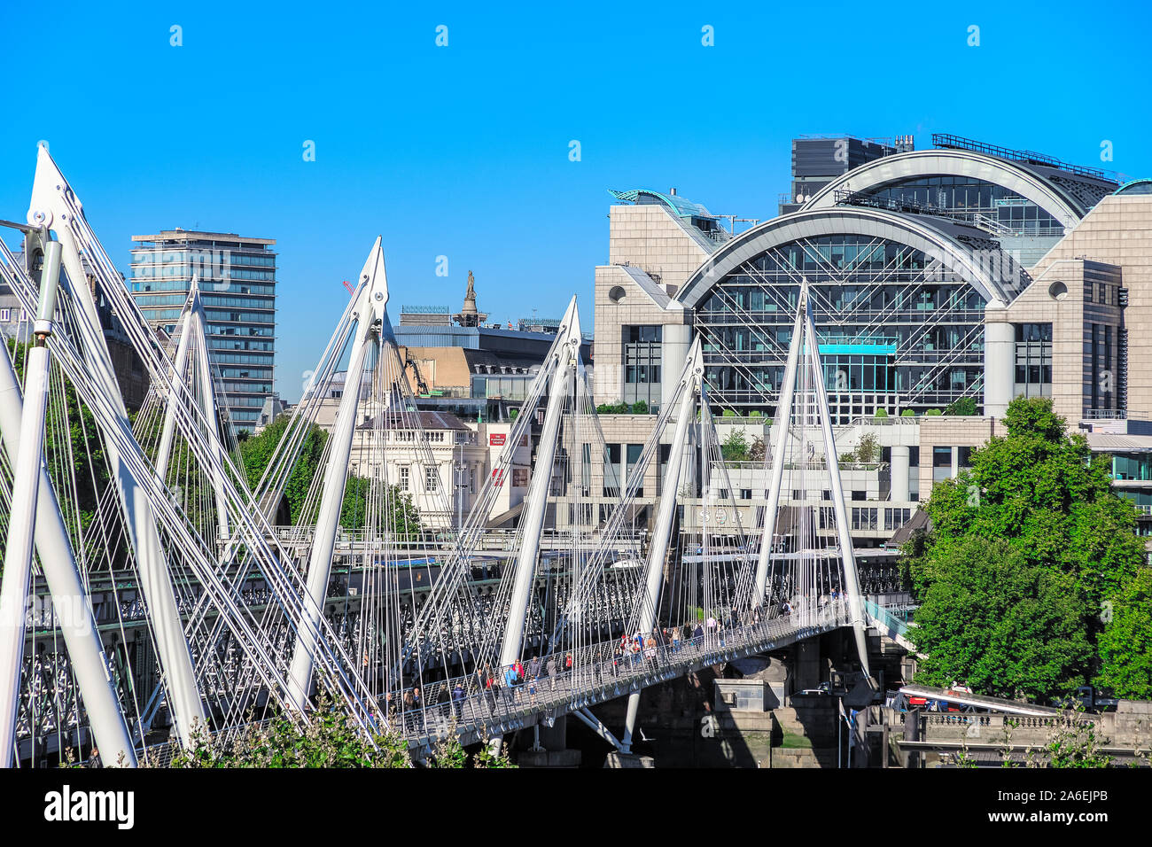 Golden Jubilee Bridges, a pedestrian footbridge, with the river side of Charing Cross station in the background in London Stock Photo