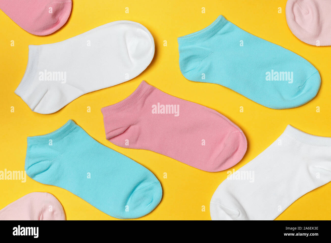 Multi-colored socks on a yellow background. Top view. Stock Photo