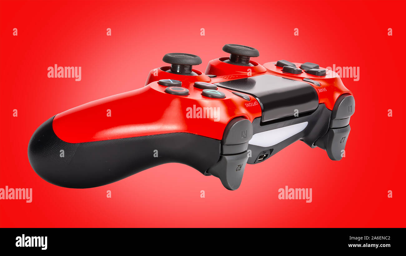 Red PS3 controller photograph with a red background, playstation three controller Stock Photo