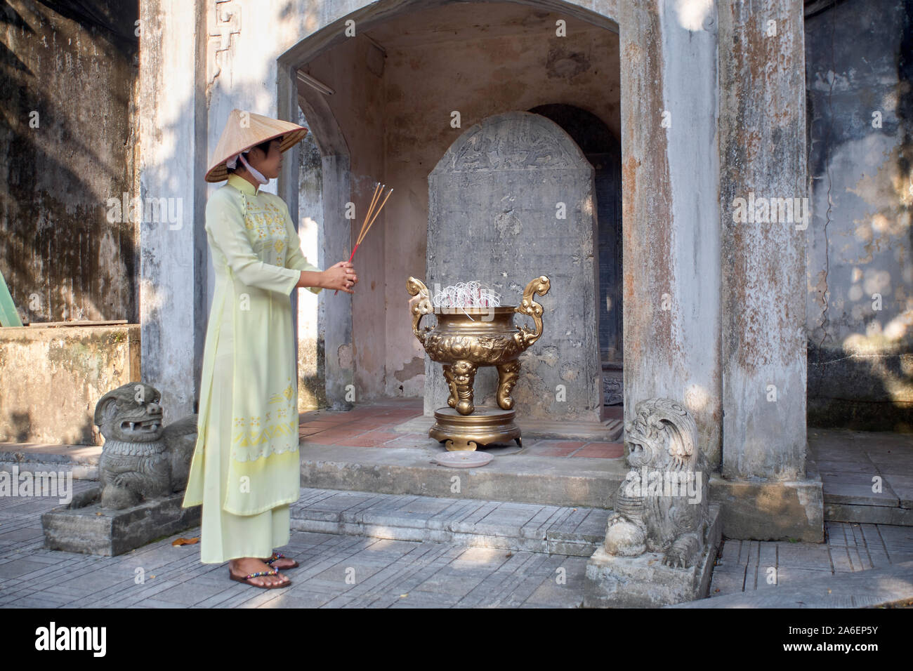 Woman wearing traditional Vietnamese dress and conical hat at a temple in Bac Ninh province, Vietnam Stock Photo
