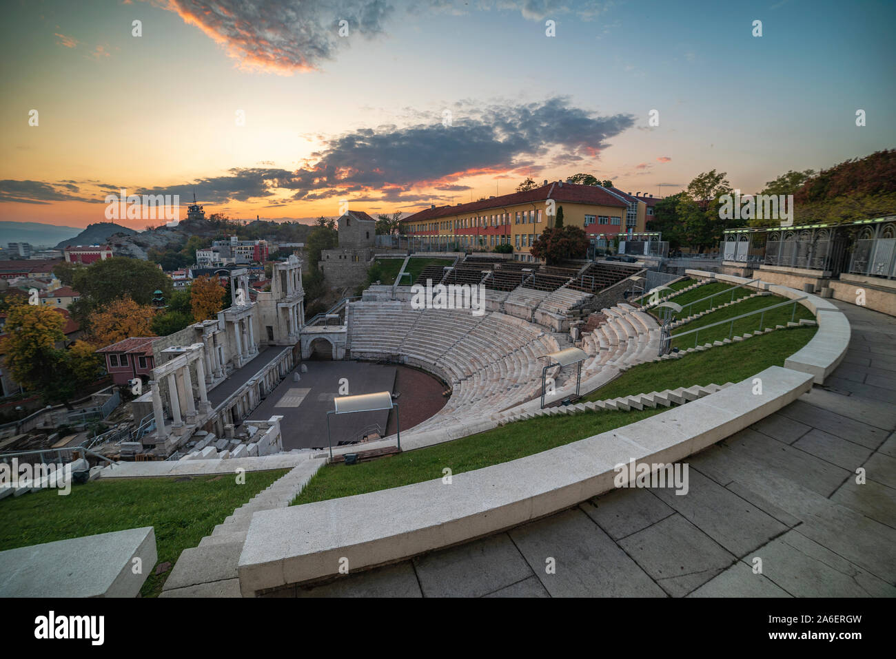 Warm autumn sunset over ancient roman amphitheatre in Plovdiv city - european capital of culture 2019, Bulgaria. The old town is included in UNESCO Stock Photo
