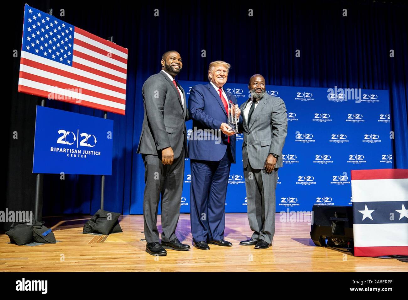 Colombia, United States of America. 25 October, 2019. U.S President Donald Trump is presented with an award by Florida State Rep. Byron Donalds, left, and Matthew Charles, during the 2019 Second Step Criminal Justice Forum at Benedict College October 25, 2019 in Columbia, South Carolina.  Credit: Shealah Craighead/White House Photo/Alamy Live News Stock Photo