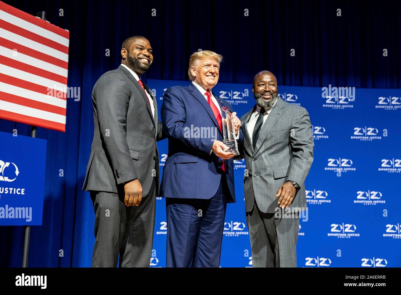Colombia, United States of America. 25 October, 2019. U.S President Donald Trump is presented with an award by Florida State Rep. Byron Donalds, left, and Matthew Charles, during the 2019 Second Step Criminal Justice Forum at Benedict College October 25, 2019 in Columbia, South Carolina.  Credit: Shealah Craighead/White House Photo/Alamy Live News Stock Photo
