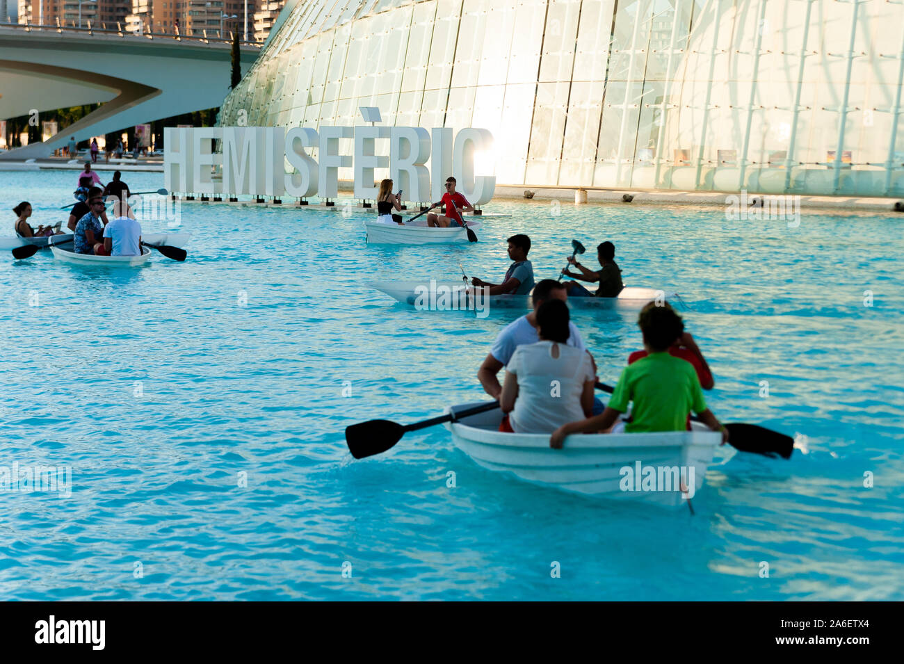 Valencia, Spain - 10 august 2019: people enjoy a boat ride inside the pool of city of arts and sciences in valencia at sunset with queen sofia palace Stock Photo
