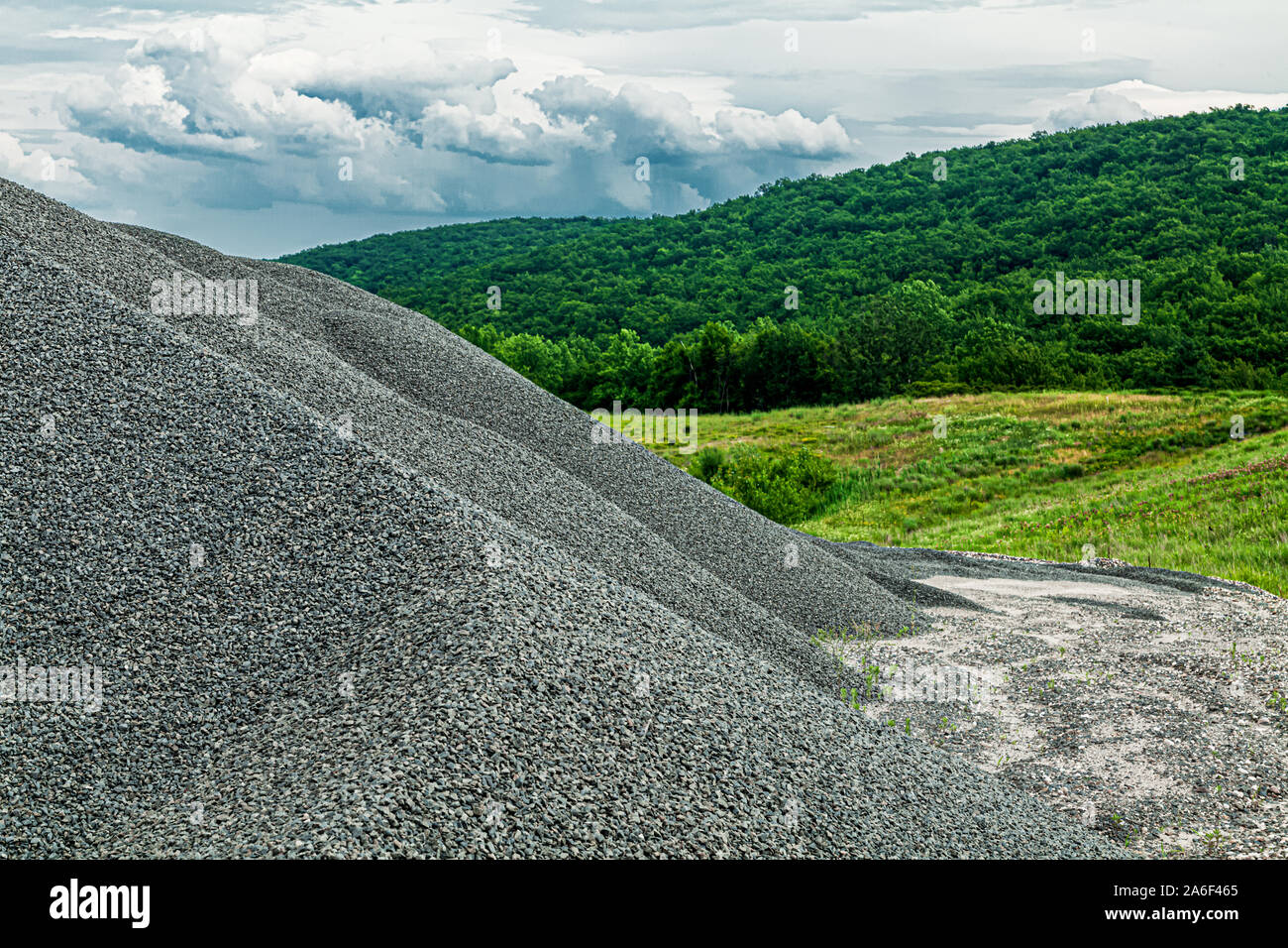 Piles of gravel in front of a lush scenic background Stock Photo