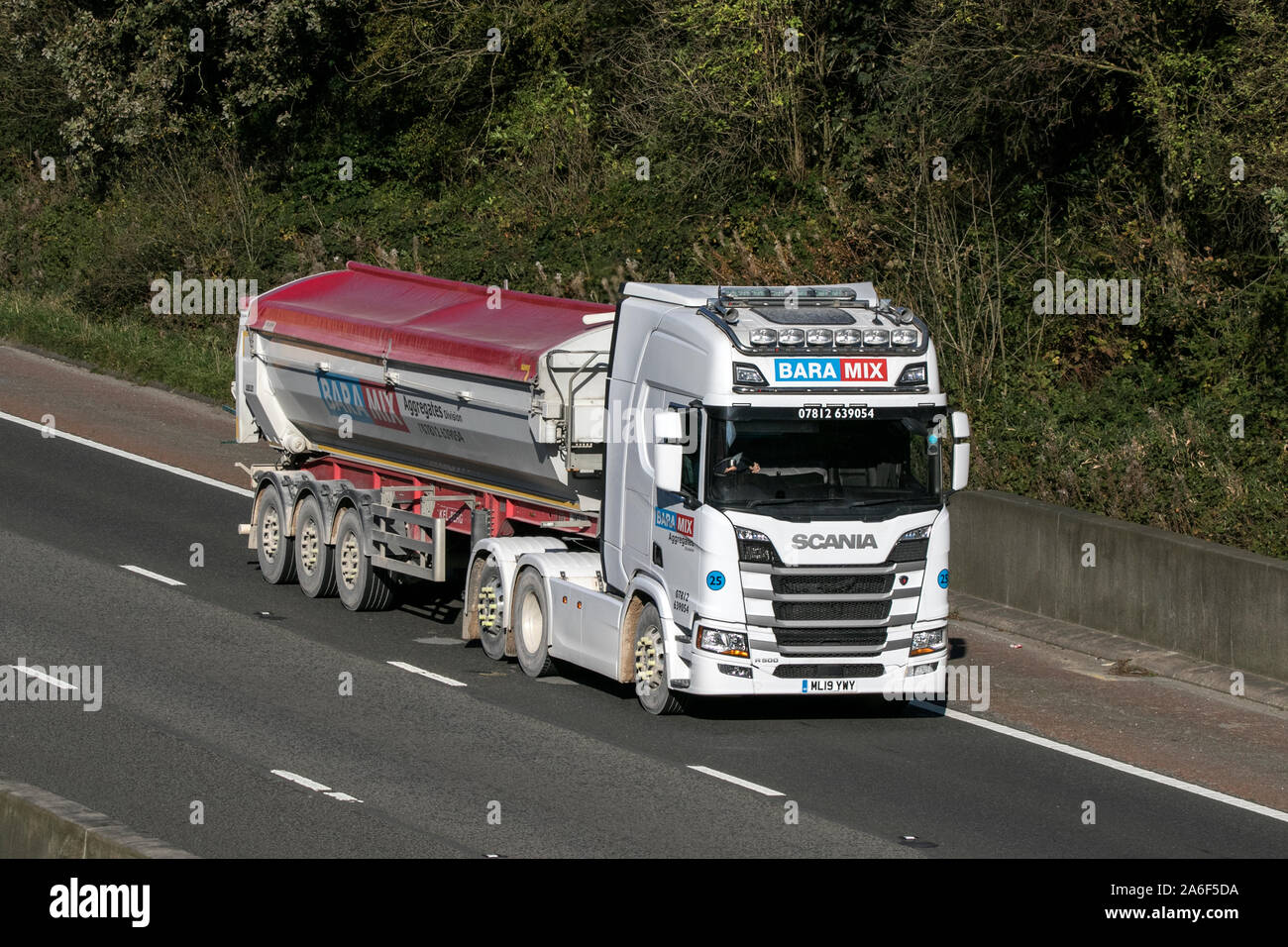 A Baramix aggregate transport curtain sided articulated Scania R500 semi truck traveling on the M6 motorway near Preston in Lancashire, UK Stock Photo