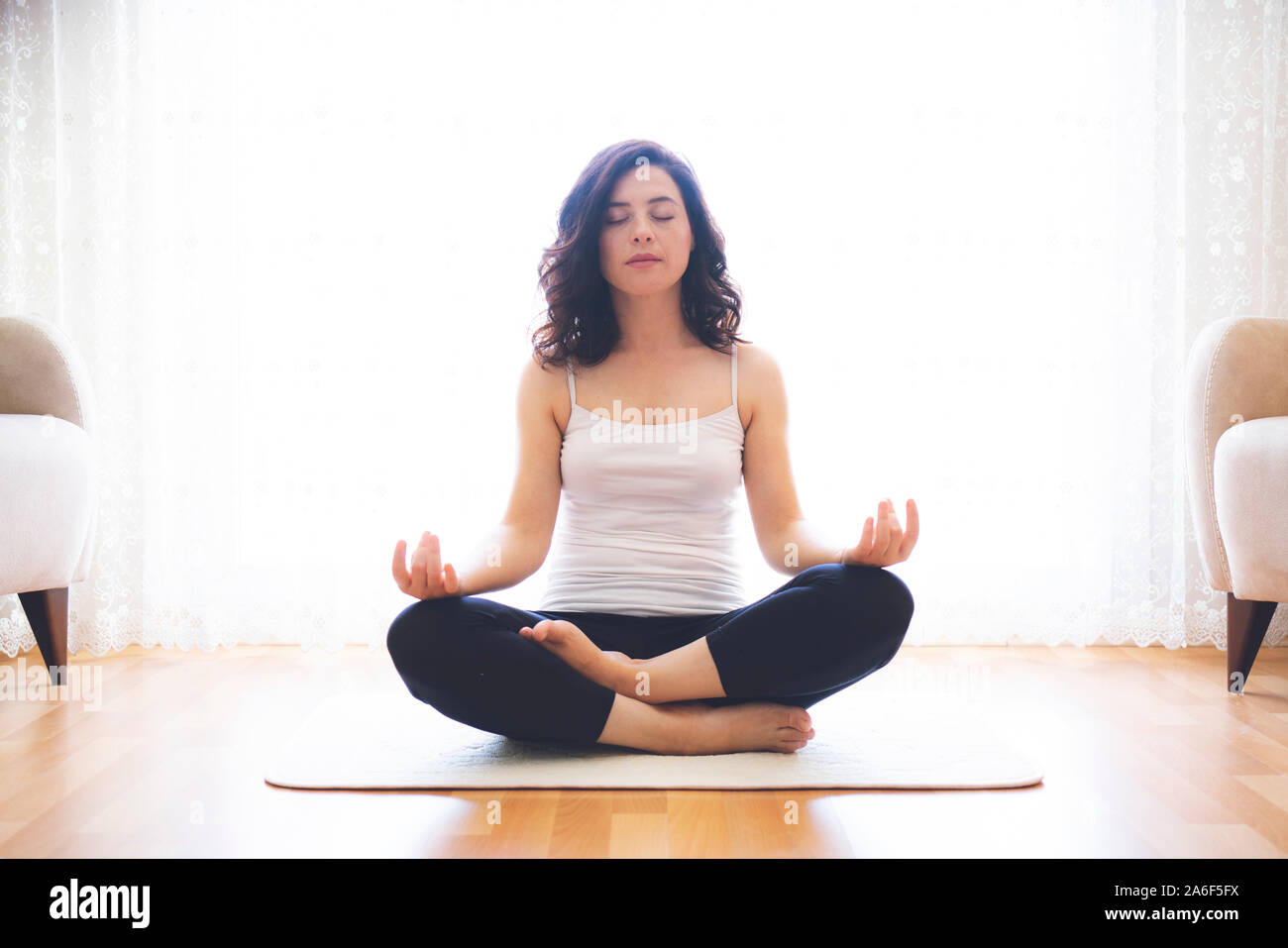 Yoga at home. Keep calm. Attractive young woman sitting on lotus ...