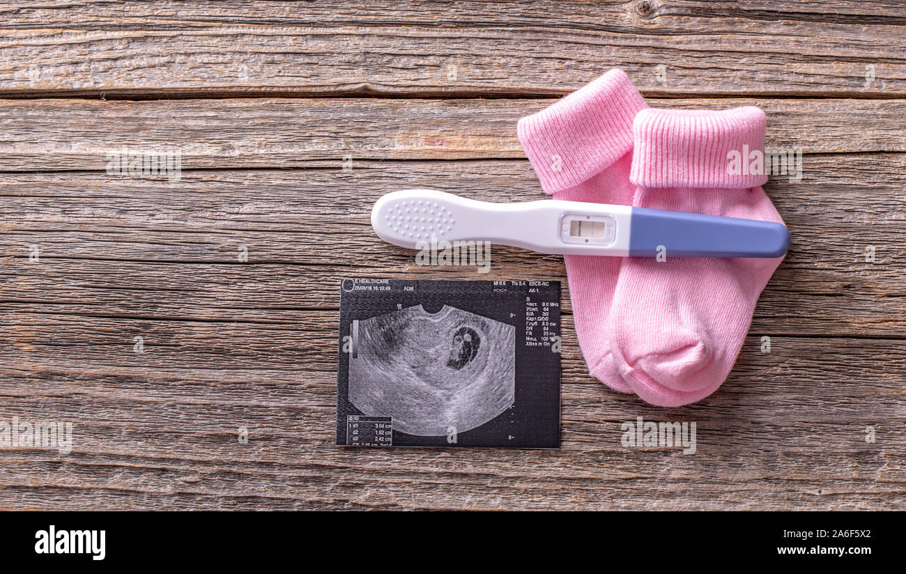 Pregnancy test as a still life on a wooden background. Stock Photo