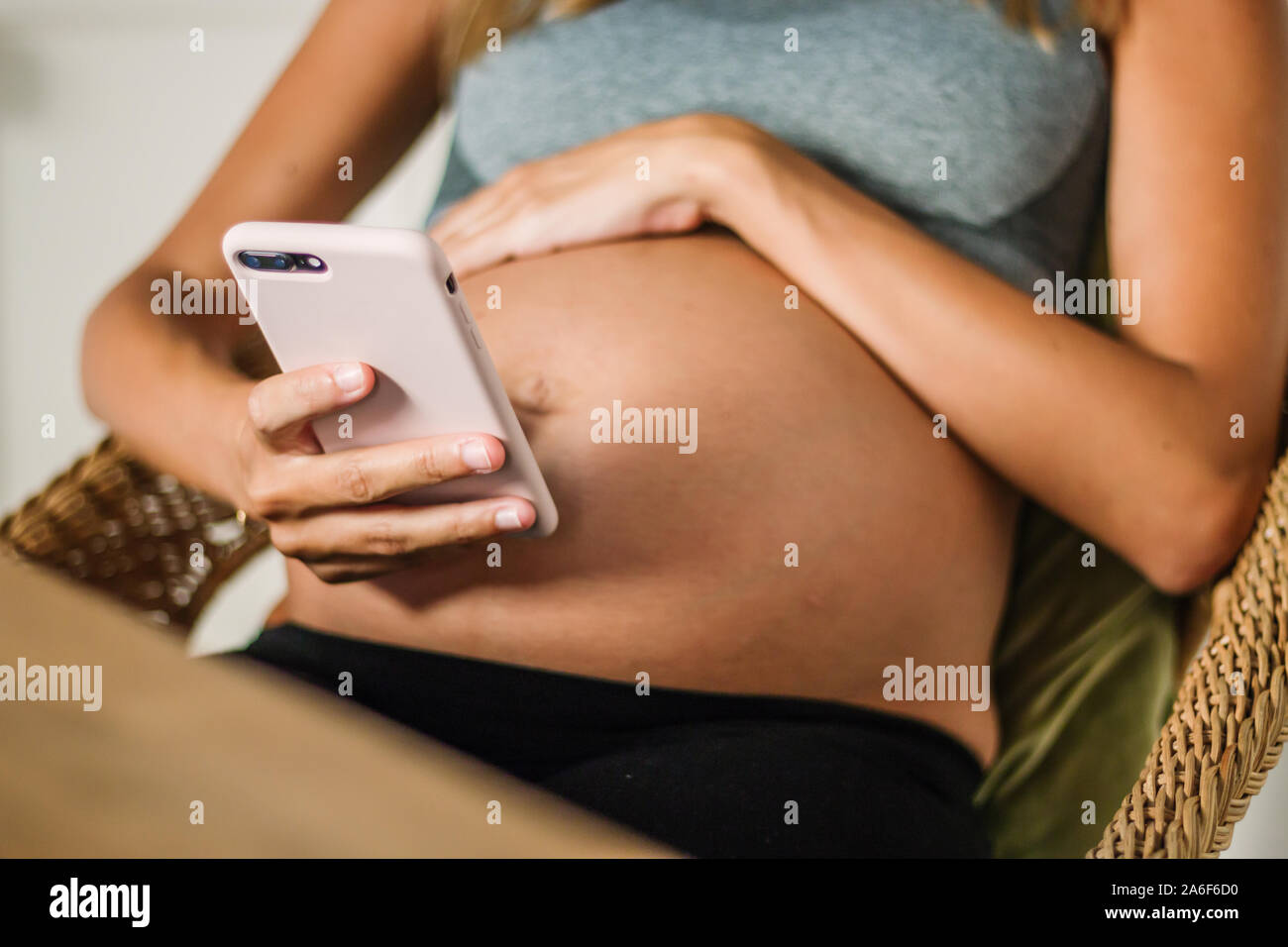 Shot of beautiful pregnant young woman using her mobile phone while resting at home Stock Photo