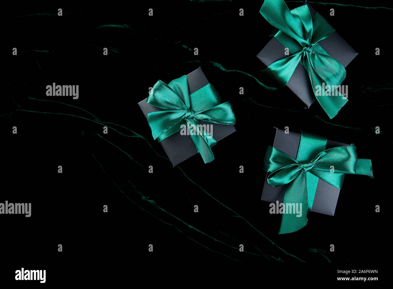 Luxury black gift boxes with green ribbon on shine velvet background ...