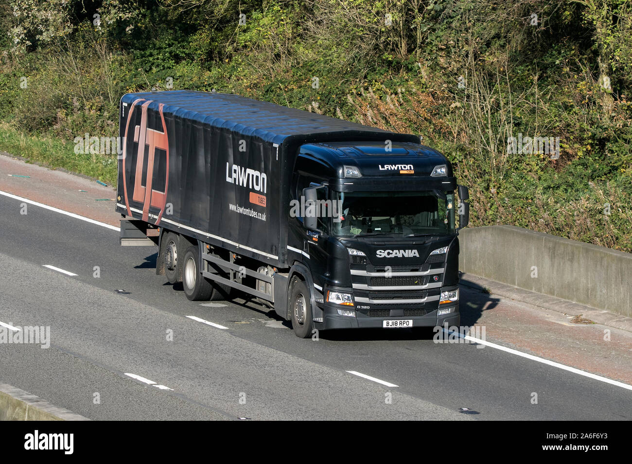 A Lawton Tubes Scania G420 rigid curtain sided semi truck traveling on the M6 motorway near Preston in Lancashire, UK Stock Photo