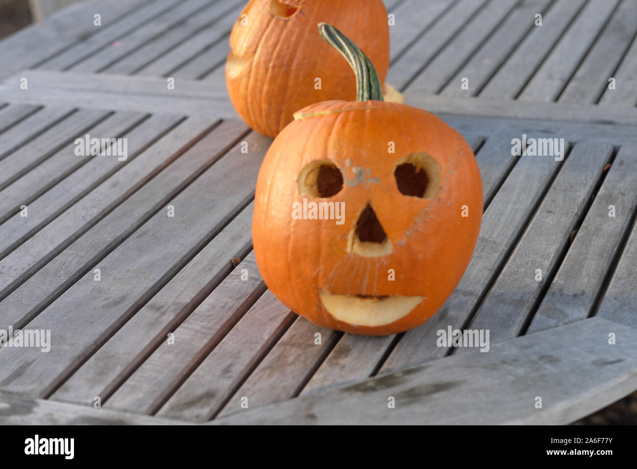 Carved Pumpkins, Smiling, on a Table Out of Doors Facing and Side