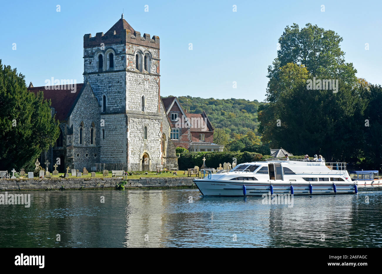 Berkshire - River Thames - Bisham church - passing river cruiser - reflections - summer day - sunlight and blue sky Stock Photo