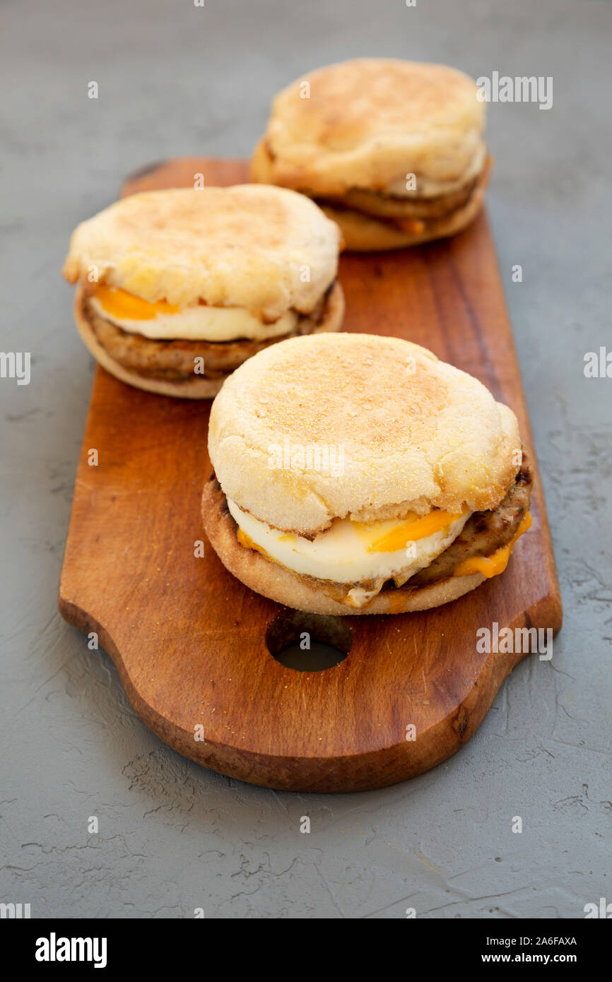 Homemade pork roll egg sandwich on a rustic wooden board on a gray