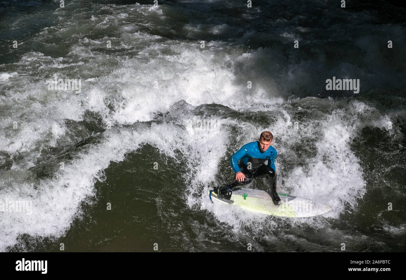 A surfer rides the artificial wave at Eisbachwelle, Munich, Germany. Part of a man made river, the spot is used for an annual surfing competition. Stock Photo