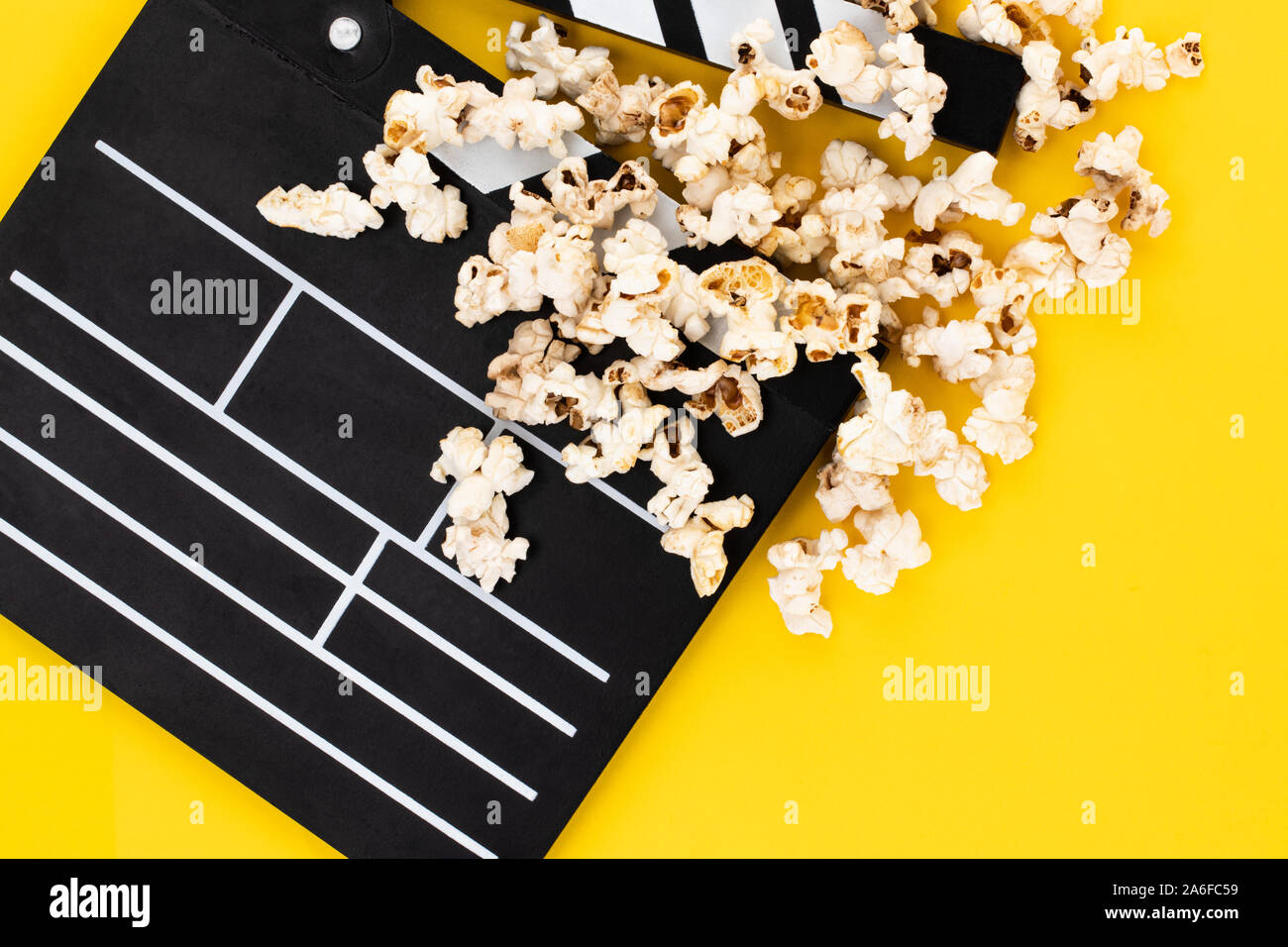Popcorn and clapperboard on colorful background. Top view. Stock Photo