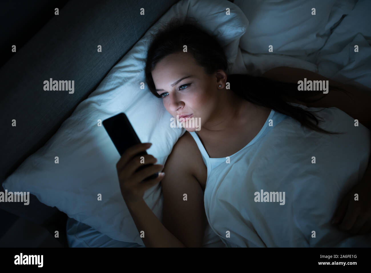 Чтение перед сном. Девушка с телефоном улыбается. Девушка готовится ко сну. Девушка в постели ночью. Девушка засыпает.